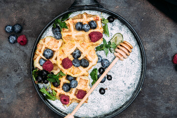 Belgian sweet waffles with blueberries, raspberries and honey