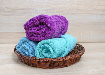 terry towels in a wicker basket on a wooden background