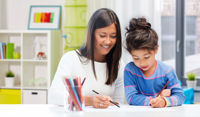 Obraz premium family, hobby and people concept - happy mother and daughter drawing over home background