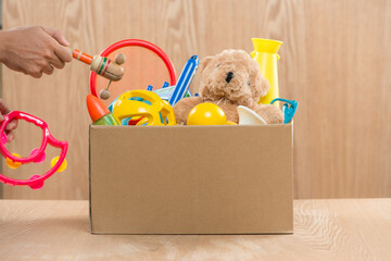 Male volunteer holding donation box with old toys.