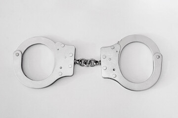 gray metal handcuffs on a white background.