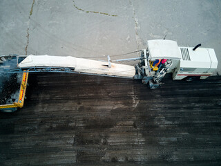 Top view, The road milling machine removes the top layer of asphalt from the road section and loads...