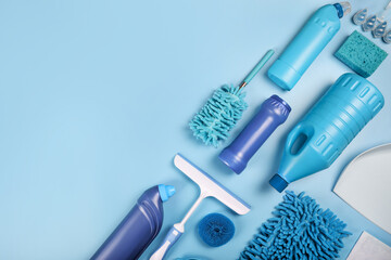 Blue cleaning supplies on blue background. Top view