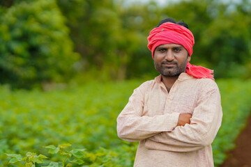 Naklejka na ściany i meble Young indian farmer standing in cotton agriculture field.