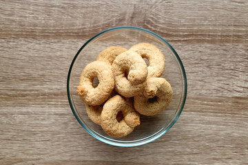 Bowl of biscuits on wooden table. Top view.