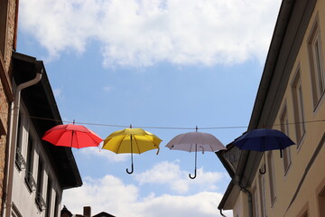 Bunte Regenschirme hängen über der Straße.