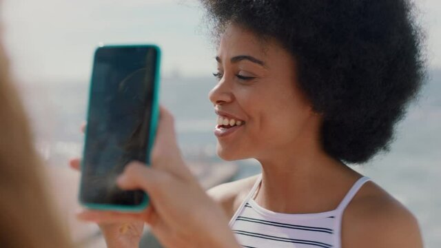 beautiful woman with afro eating ice cream on beach posing for friend taking photo using smartphone girl friends sharing fun summer day on social media 4k