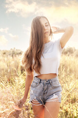 Beautiful young woman in a flower field on a sunny day.