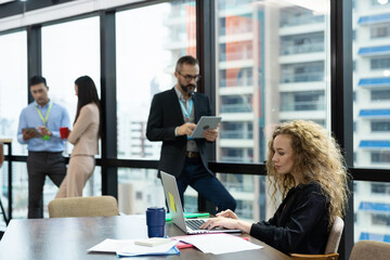Businessman and businesswoman working laptop computer and tablet in the office with city blur background