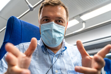 Fototapeta na wymiar Man in protective medical mask conducts remote business online conference in transport. Business man seat inside and wear face mask while using video call to talking with coworkers or clients