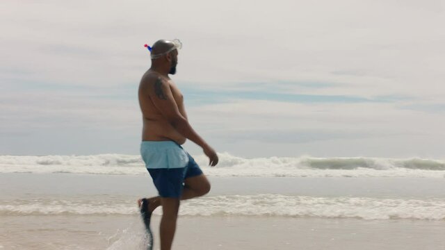 funny african american man walking on beach wearing flippers getting ready to swim enjoying summer by sea 4k