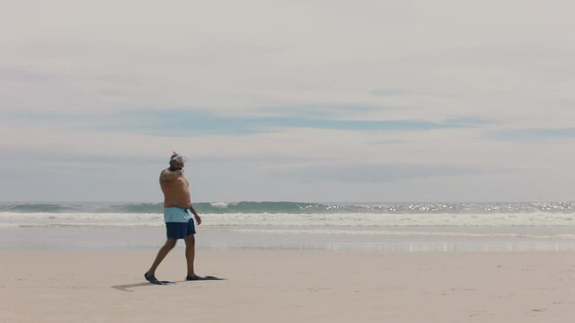 funny african american man walking on beach wearing flippers getting ready to swim enjoying summer by sea 4k