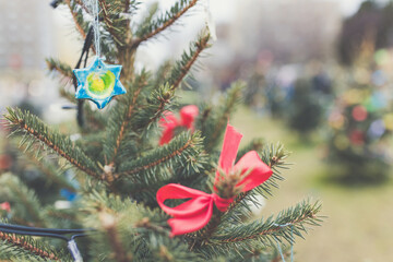 Handmade baked and painted dough decorations on a Christmas tree outdoor. DIY creative ideas for children. Environmental concept. Selective focus, copy space