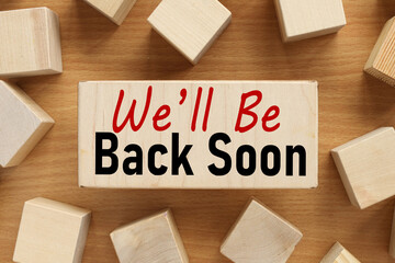 We'll Be Back Soon, text on wood board near wood cubes