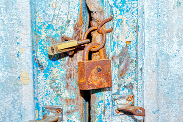 Old rusty locks of old house . Closed wooden door of abandoned house