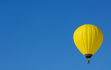 Yellow Hot air balloon on one side of the sky with space for text