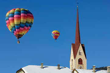 Fototapeta na wymiar hot air balloons in the blue sky above a church