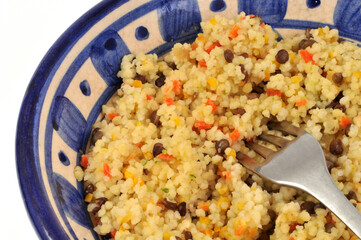 Salade de céréales avec des légumes dans un saladier avec une fourchette en gros plan