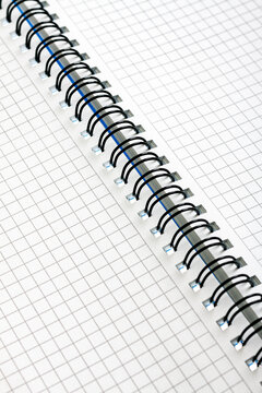 Open notebook with checkered sheets with a spring