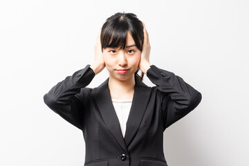 両手で耳を塞ぐ若いビジネスウーマン