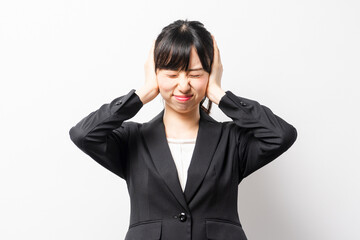 両手で耳を塞ぐ若いビジネスウーマン