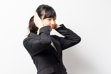両手で耳を塞ぐ若いビジネスウーマン