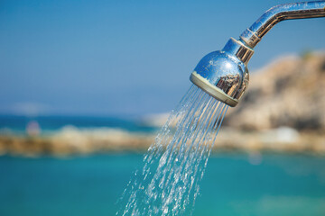 Old included shower on the beach. Sea background. Close up