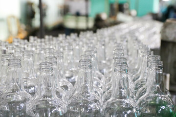 rows of empty bottles at bottling plant with swallow depth of field. Horizontal