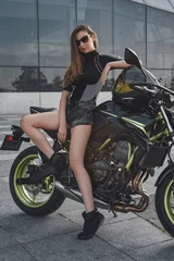 Foto op Plexiglas Woman with slim figure and dark motorbike outside © Fxquadro