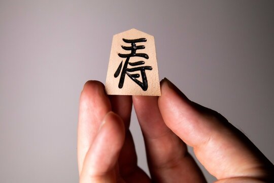 A man holding Shogi king piece