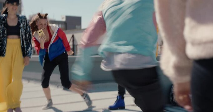 man breakdancing on rooftop at hip hop dance party performing crazy breakdance moves with friends dancing and celebrating 