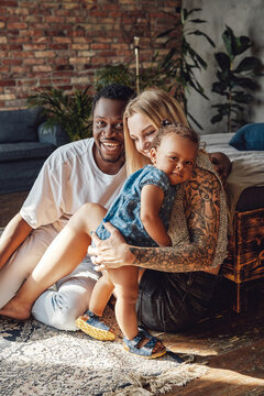 Mixed Race Family Posing Together On Camera Inside Room