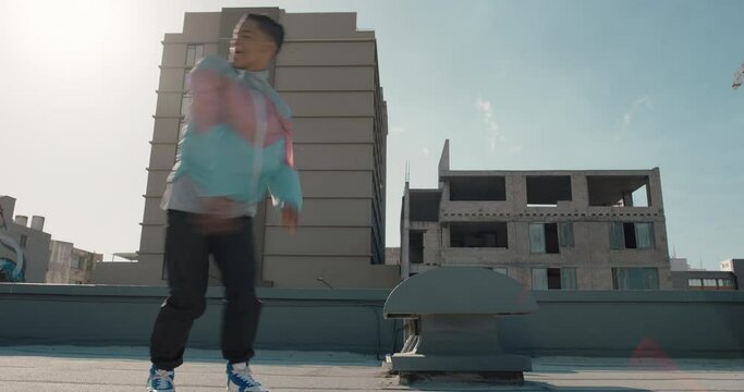 dancing man jumping somersault breakdancer practicing dance routine on rooftop in urban city