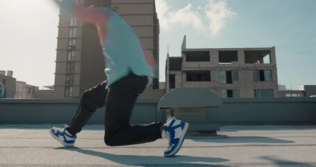 dancing man jumping somersault breakdancer practicing dance routine on rooftop in urban city