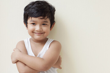 Cute Asian child little Thai boy 4 year old wearing a red sweater he have smile laugh face happy kid concept.  