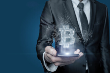 Businessman shows on the phone Bitcoin on blue background.