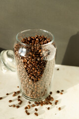 coffee beans in a glass jar stand on a white table