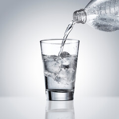 Enchendo copo de água mineral, em fundo branco