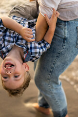  Mother and son having fun and playing at the seaside. summer vacation.