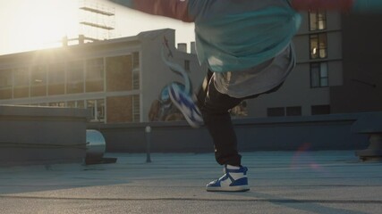 dancing man breakdancing on roof top hip hop dancer practicing dance routine performing freestyle moves in city at sunset