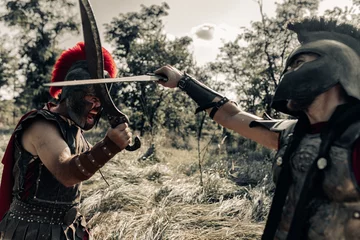 Tuinposter Battle with swords between two ancient warriors on meadow. © Stanislav