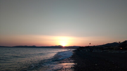 Seaside and a flag silhouette in a sunset