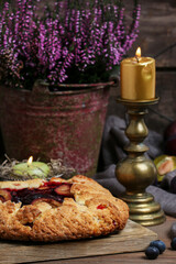 Traditional round plum pie on the table.