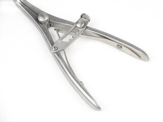 steel surgical clamp with retainer on a white background