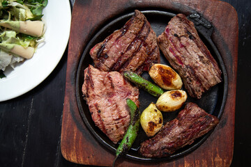 Grilled meat. Steak with blood in a pan and salad