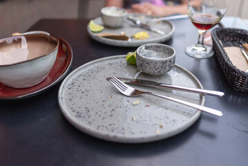 dirty plates after dinner finished, forks and spoons after eating in the restaurant. The concept of mess, dirty dishes.