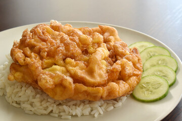 Thai omelette with rice and cucumber.  Popular and traditional Thai food. 