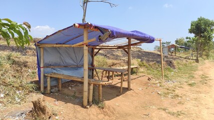 photo of a simple hut made of bamboo and used tarpaulin that serves as a place to rest and shelter