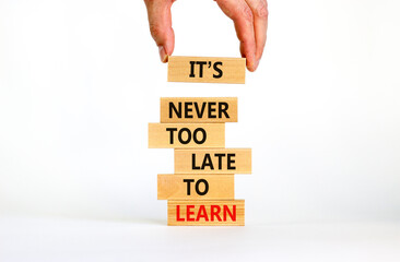 Learn symbol. Wooden blocks with words 'It is never too late to learn'. Businessman hand. Beautiful...