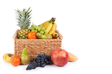 Mix variety of fresh juicy colorful exotic tropical fruits in basket on white background
